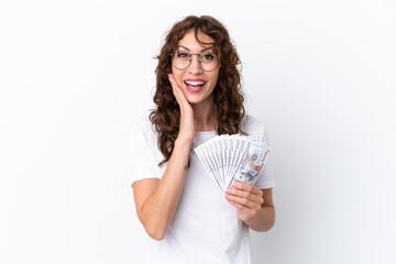 Wall Mural - Young woman with curly hair taking a lot of money isolated background on white background with surprise and shocked facial expression