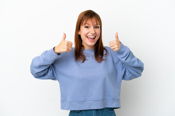 Wall Mural - Redhead girl isolated on white background giving a thumbs up gesture