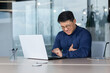 © Liubomir - Heart attack at work. A young Asian man is sitting at a desk in the office, holding his heart. A stroke, holding his chest. grimaced, feels severe pain, needs help.