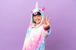 © luismolinero - Little kid wearing a unicorn pajama isolated on purple background happy and counting three with fingers