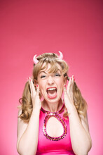 Portrait Of Woman Wearing Devil Horns And Screaming