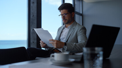 Lawyer reading contract papers at sea view. Manager professional at work