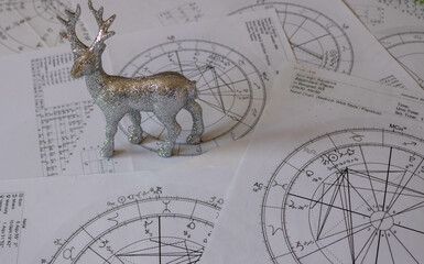 Wall Mural - Astrological natal charts with a silver reindeer ornament, winter and holiday concept