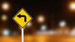 Yellow sign with left turn direction arrow on dark night blur background