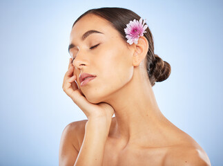 Wall Mural - Face, beauty skincare and woman with flower in studio on blue background mockup. Floral cosmetics, organic makeup and female model with eyes closed, healthy or glowing skin after spa facial treatment