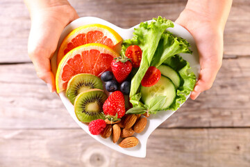 Wall Mural - diet food concept- hand holding plate with fresh fruit and vegetable