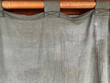 Light gray cotton curtain texture interior hanging on wooden bar. Beauty decoration in room.