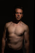 © Collins Photography - Sexy portrait of muscular handsome topless male isolated against a black background