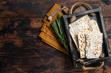 Passover Matzos Of Celebration With Matzo Unleavened Bread In A Wooden Tray With Herbs. Wooden Background. Top View. Copy Space
