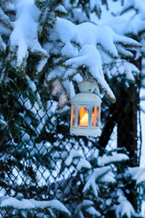 Sticker - White lantern is hanging on a porch. Garden covered with snow. Winter outdoor decorations for Christmas.