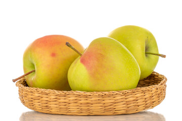 Three green sweet apples on a straw plate, macro, isolated on white background.