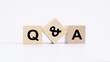 QA - acronym from wooden blocks with letters, questions and answers concept, top view on white background