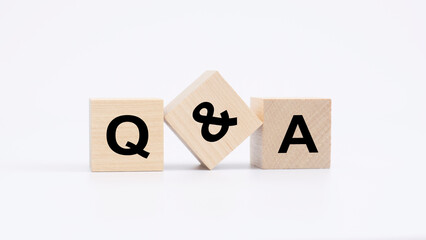 qa - acronym from wooden blocks with letters, questions and answers concept, top view on white backg