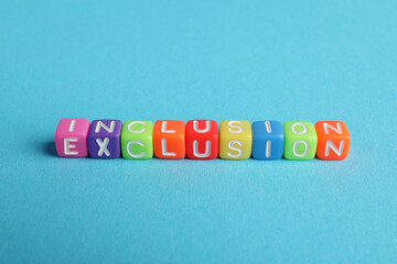 Wall Mural - Colorful cubes with word Inclusion on light blue background, above view