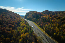 View From Above Of I-40 Freeway In North Carolina Heading To Asheville Through Appalachian Mountains In Golden Fall Season With Fast Driving Trucks And Cars. Interstate Transportation Concept