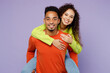© ViDi Studio - Young fun couple two friends family man woman of African American ethnicity wear casual clothes together giving piggyback ride to joyful, sit on back isolated on pastel plain light purple background.