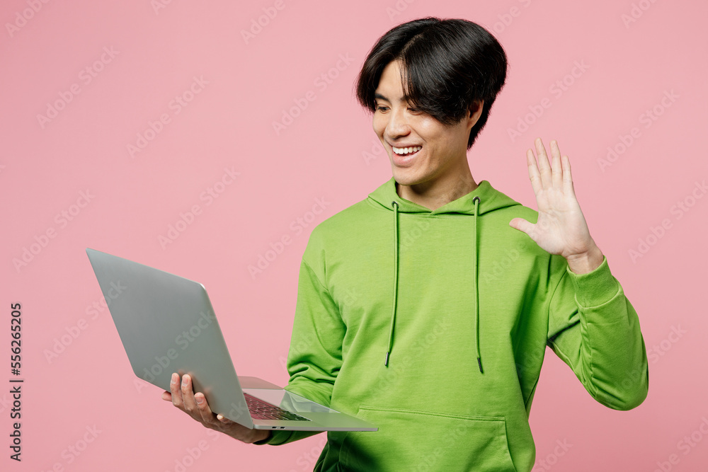 Young happy smiling smart IT man of Asian ethnicity wear green hoody ...