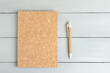 Closed notebook with pen on a gray wooden background