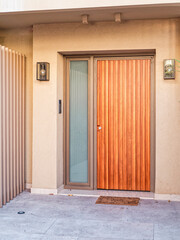 Poster - Contemporary house entrance with a natural wooden door, Athens , Greece.