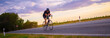 © Solid photos - Young sports man cycling with bicycle on the road in summer