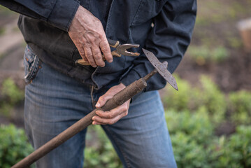 Wall Mural - man fixing a hoe, with pliers