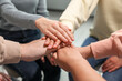 © New Africa - Group of people holding hands together indoors, closeup. Unity concept
