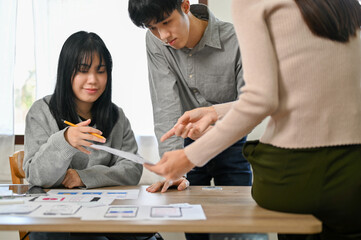 Canvas Print - group of millennial asian mobile application developers startup are in the meeting