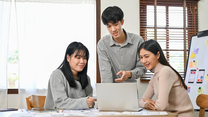 Canvas Print - group of millennial asian website and mobile application developers startup are in the meeting