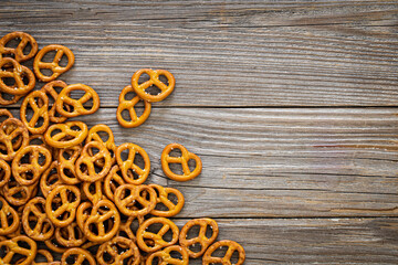 Wall Mural - Salted mini pretzels on a wooden background, top view, copy space.