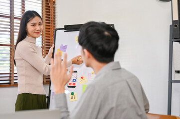 Canvas Print - female designer presenting her mobile application's interface prototype to a developer team.