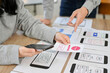 © bongkarn - cropped image, A team of mobile application interface designers are in the meeting