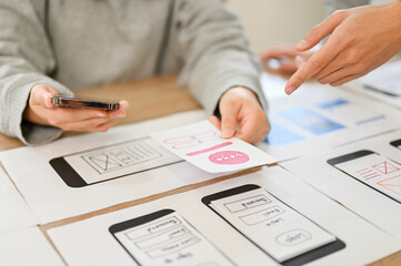 Canvas Print - a team of mobile application interface designers are in the meeting. cropped image