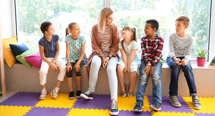 Poster - Cute little children with teacher in primary school