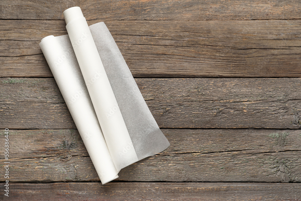 Rolls of baking paper on wooden background
