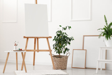 Wall Mural - Interior of light room with easel, houseplants and blank frames