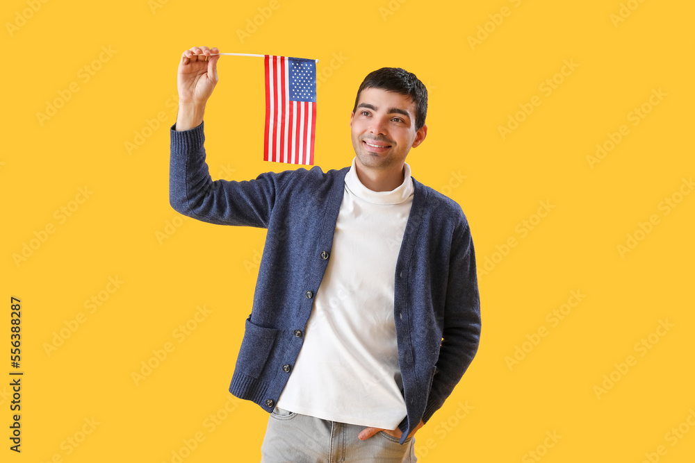 Young man with USA flag on yellow background