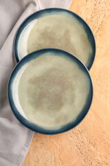 Wall Mural - Stylish plates with grey napkin on beige grunge background