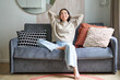 © Mix and Match Studio - Portrait of happy asian woman feeling lazy, stretching on sofa and smiling pleased, relaxing at home, resting from work