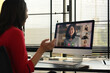 © Prathankarnpap - Rear view of businesswoman having video call, discussing issues remotely online with diverse coworkers