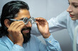 © Surachai - An eye doctor examines a male patient in a clinic with modern equipment.