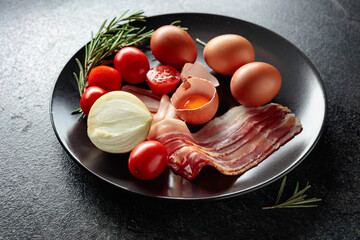 Wall Mural - Smoked bacon with eggs, tomatoes, onions, and rosemary.
