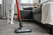 housewife cleanup with electric handheld vacuum duster in apartment