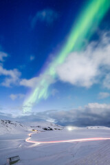 Canvas Print - Aurora Borealis in Iceland. Northern Lights over the road. A winter night landscape with bright lights in the sky. Landscape in the north in winter time. A popular place to travel.