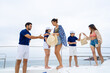 © CandyRetriever  - Man and woman yacht crew in uniform helping group of passenger tourist get on luxury private catamaran boat yacht to sailing in the ocean on summer vacation. Cruise ship service occupation concept.