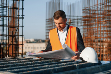 Wall Mural - Front view of man that is working on the construction site at daytime