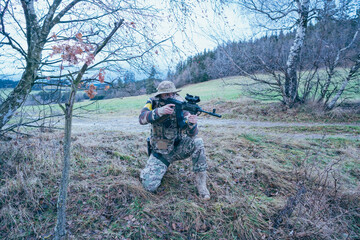 Wall Mural - Ukrainian soldier on the front line. With an assault rifle in camouflage. Yellow tape.