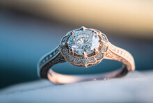 Gold Diamond Engagement Ring In The Snow, Against A Blue Blurred Bokeh Background, Created With Generative AI