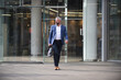 © Minet - Modern senior businessman with a bag exits modern corporation