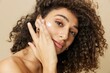 Leinwanddruck Bild - Woman beauty face close-up applying anti-aging moisturizer with fingers of her hand, skin health nails and hair, hair dryer style curly afro hair, body and beauty care concept
