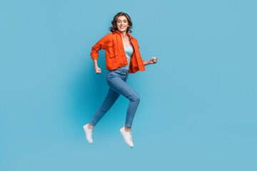 Sticker - Full body photo of young lovely lady flying running fast hurry sale shopping wear trendy orange outfit isolated on blue color background